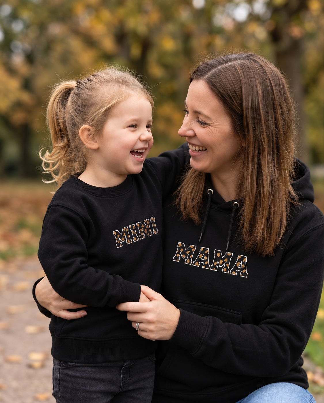 Mutter und Tochter lachend im Wild Hearts Partnerlook in Schwarz