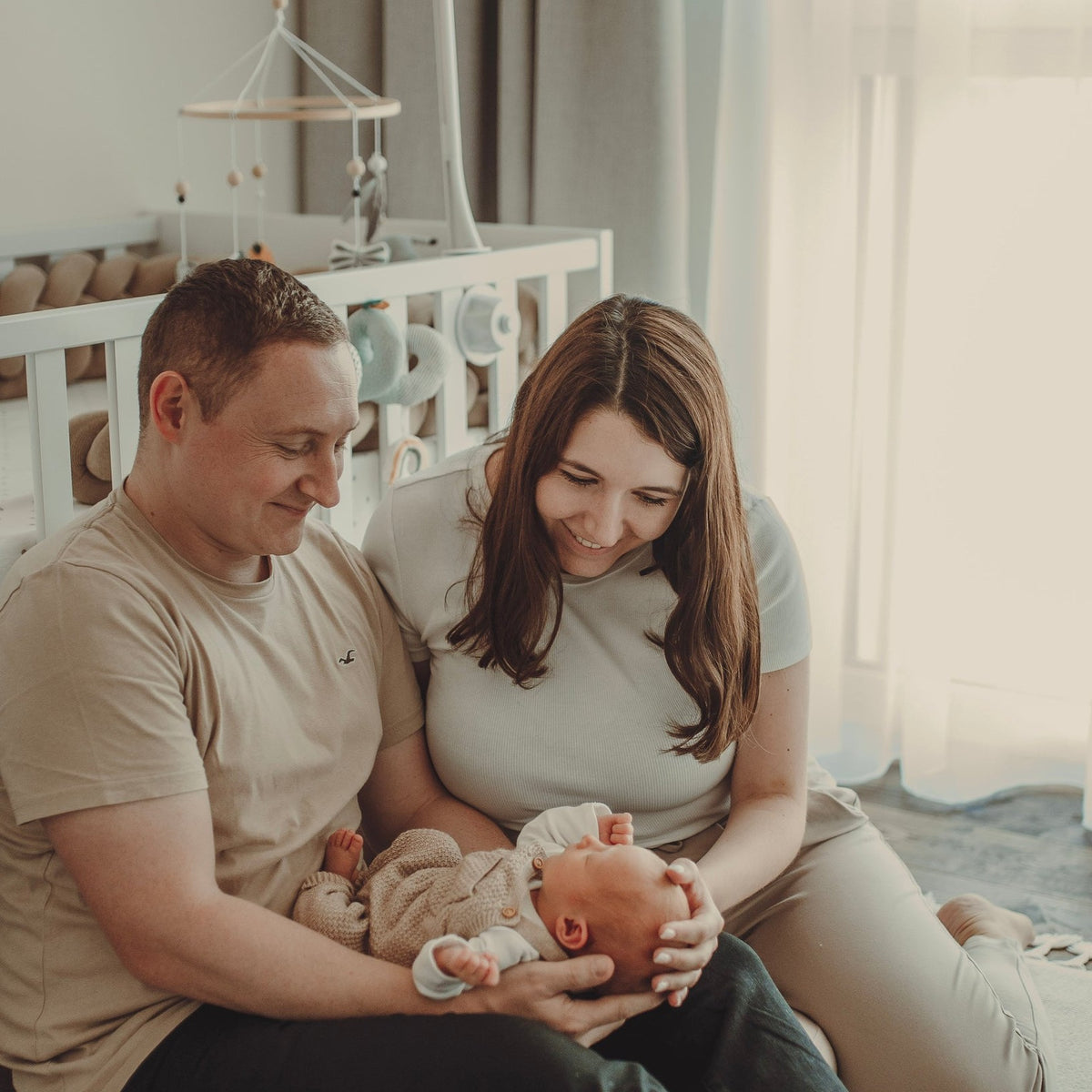 Sabrina und Pascal mit ihrem Baby im Kinderzimmer